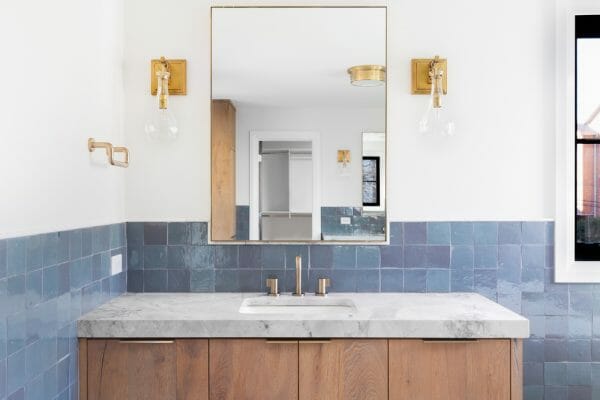 White Bathroom with Blue tile Contrast with Gold Accent Pieces